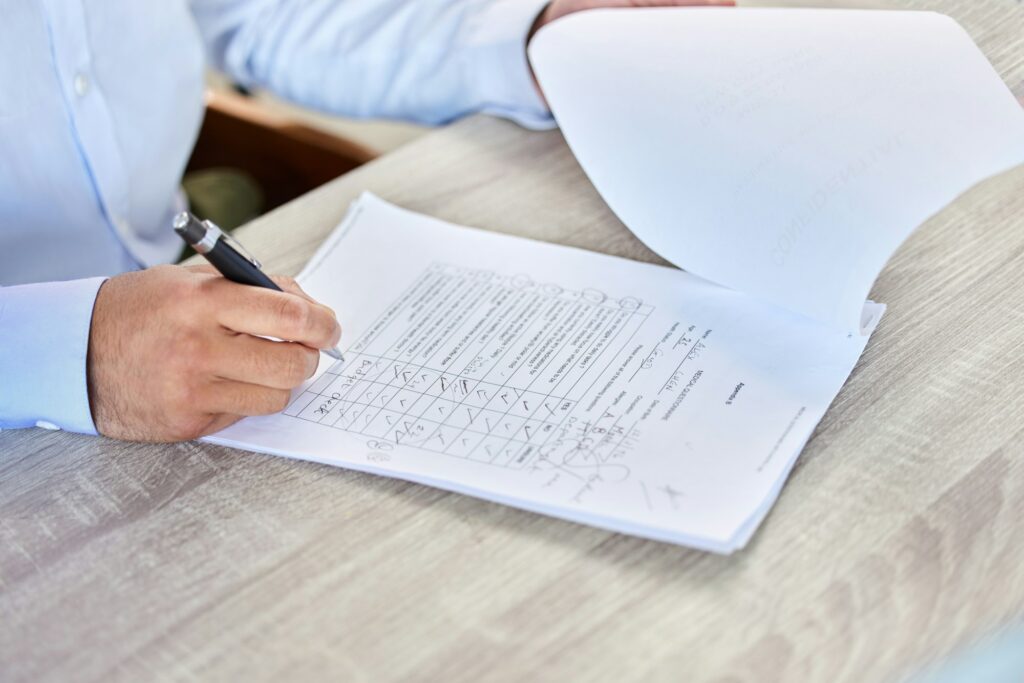 Patent filling medical form. Closeup of a business man writing on a healthcare document in an offic